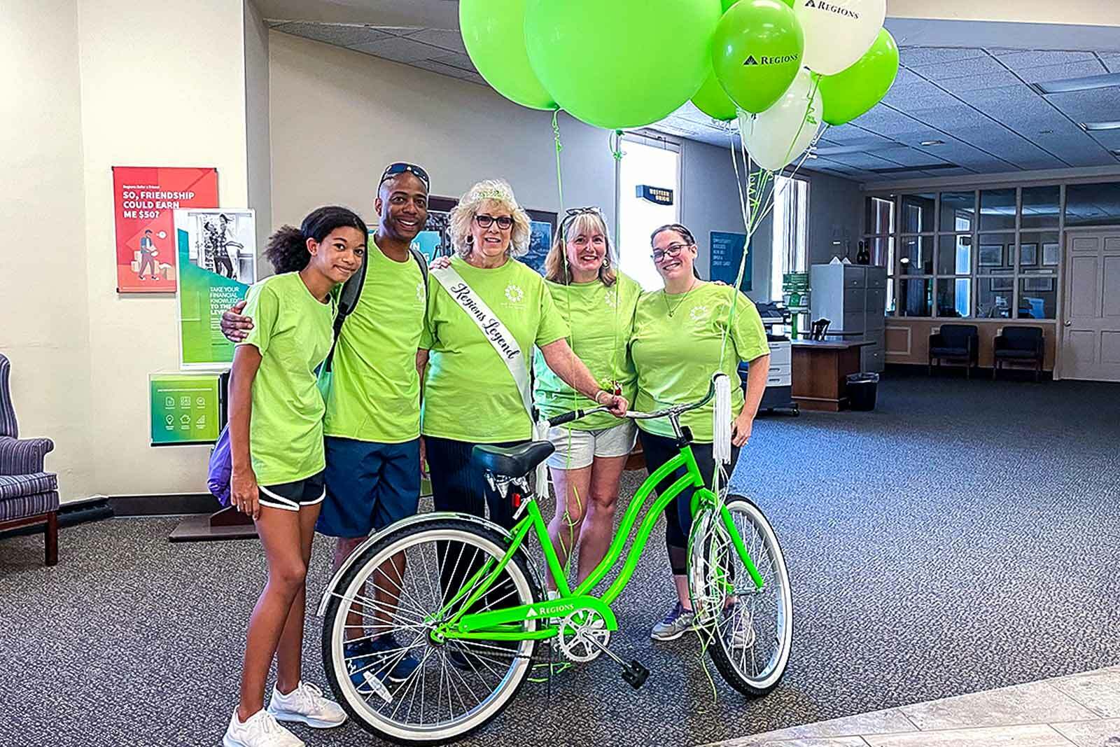 Mary Lou with team and green bike