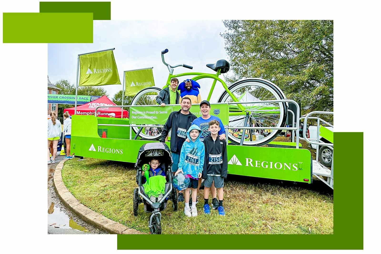 family posing in front of big green bike