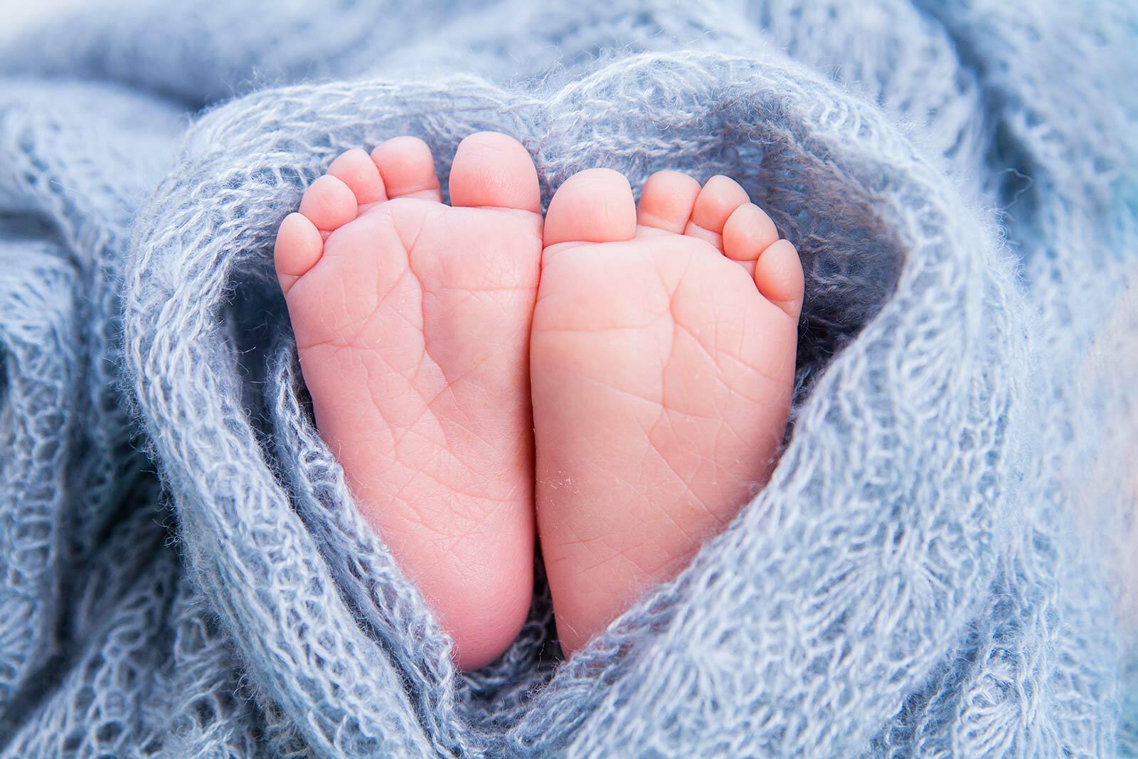 closeup image of a caucasian baby's feet wrapped in a...