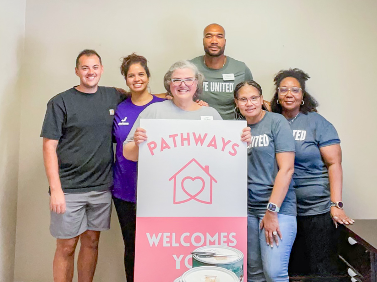 A Regions volunteer group poses with a Pathways sign