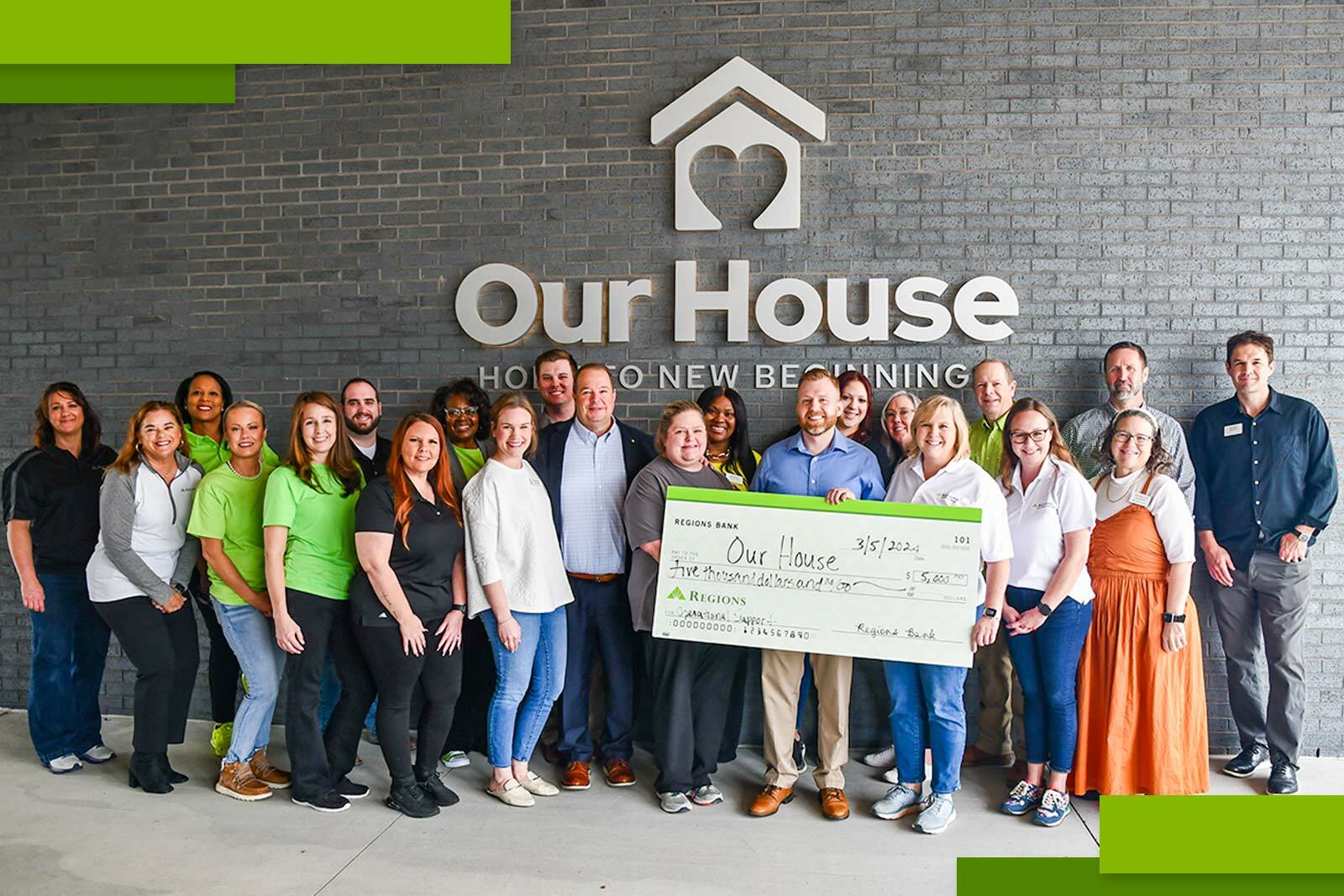 Our House group photo and check presentation