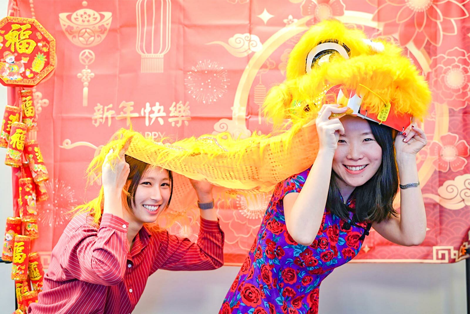 Two people celebrating Lunar New Year with a dragon.