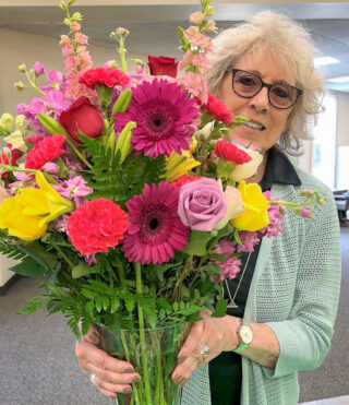 Mary Lou with bouquet of flowers.