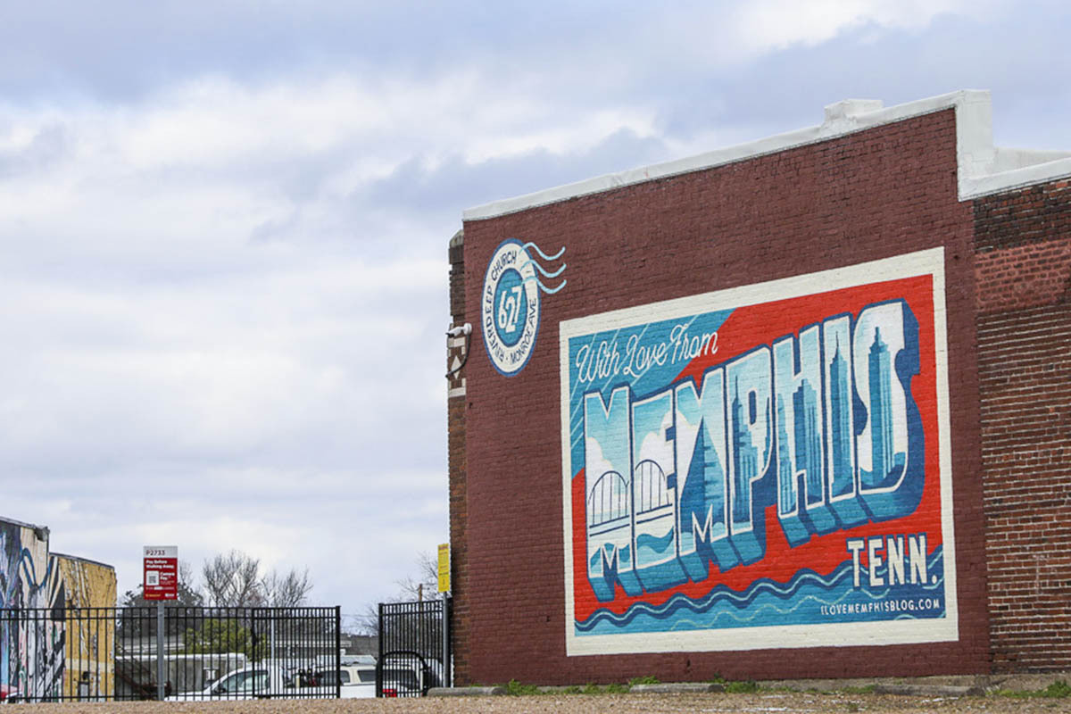 A mural of a giant postcard touting Memphis welcomes you near Edge Motor Museum.