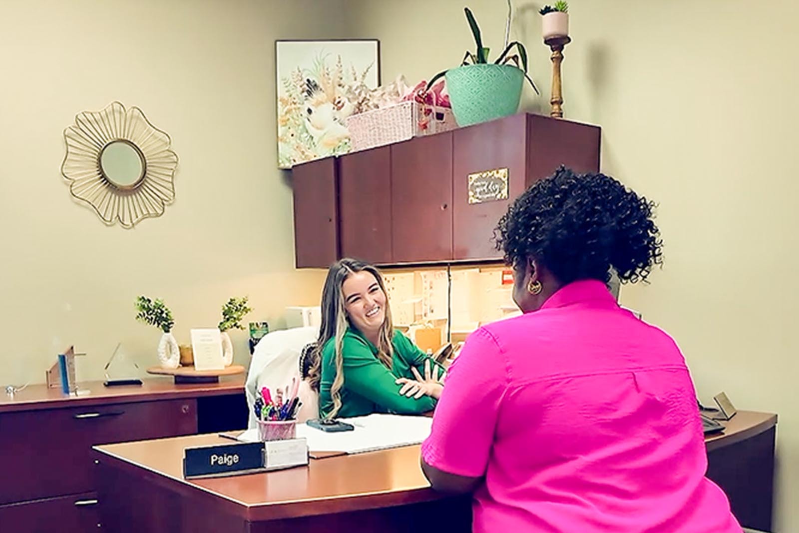 Paige Lasyone in the office at her desk having a conversation with the client. 