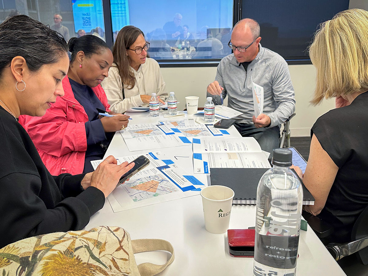 Group of people at a table discussing their strategy for the FinX Experiance.
