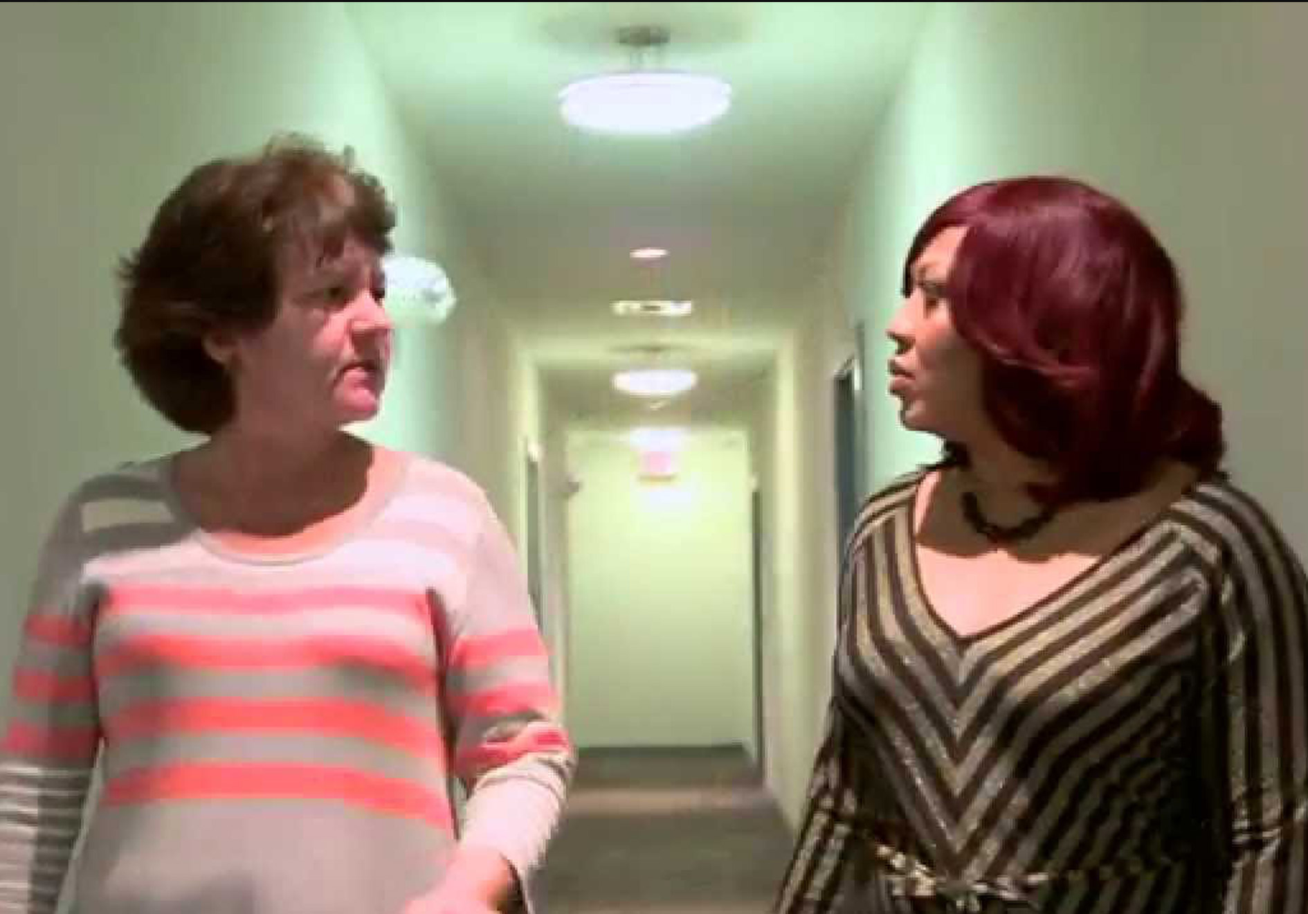 two women speaking in hallway