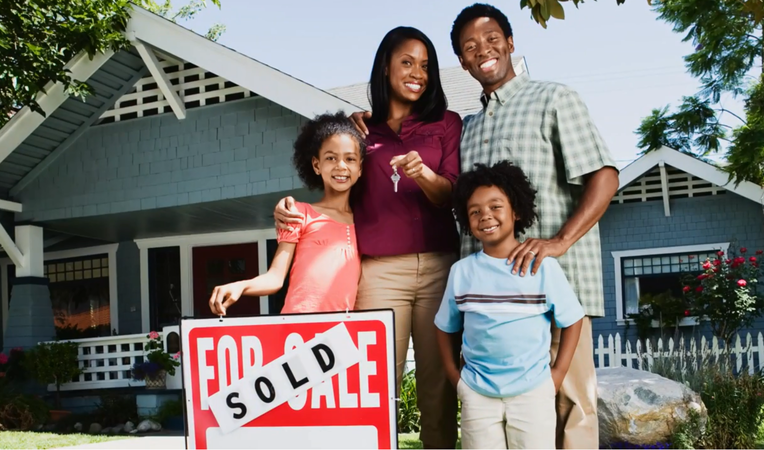 photo of family standing next to for sale sign
