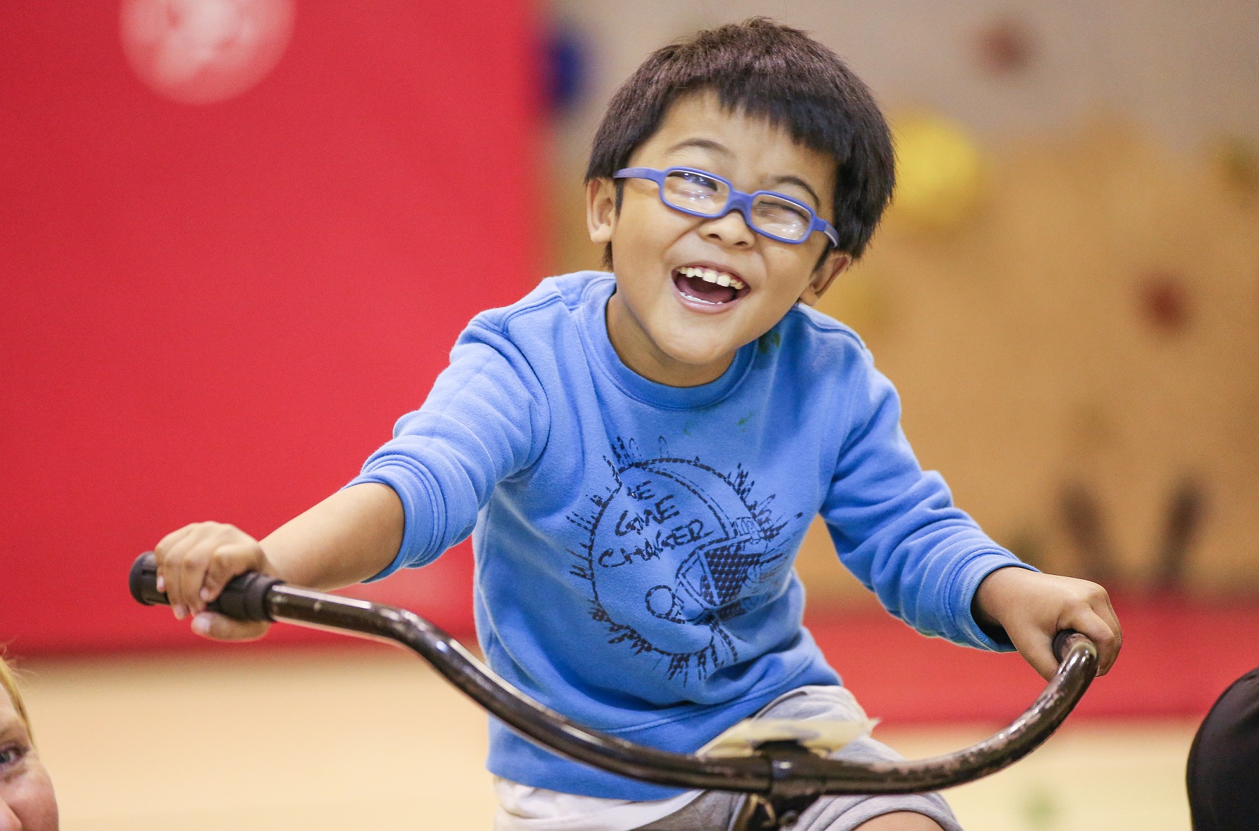 a smiling boy on a bike