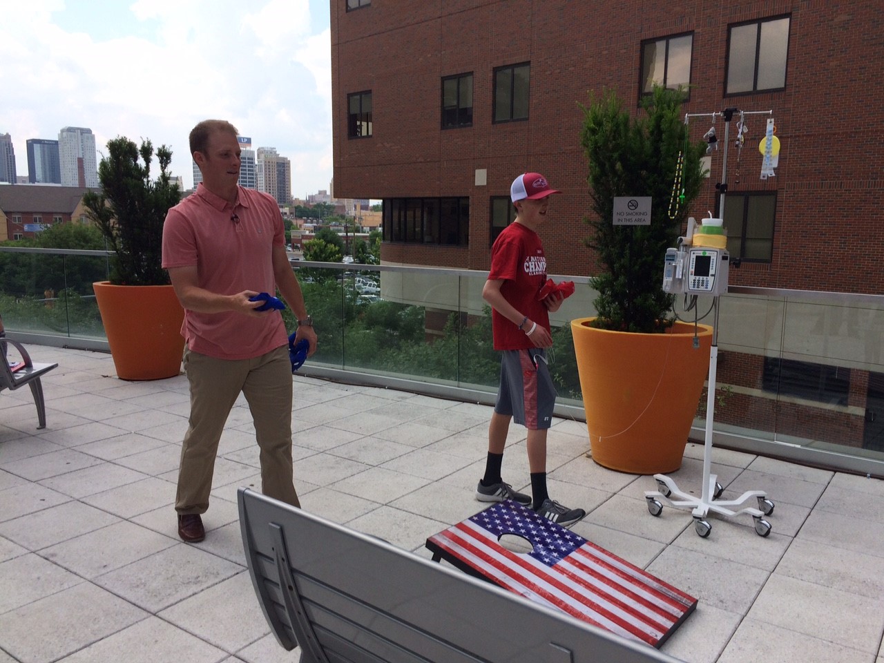 On the patio of Children's of Alabama, Greg McElroy and Kolbe play for the title in a game of cornhole.