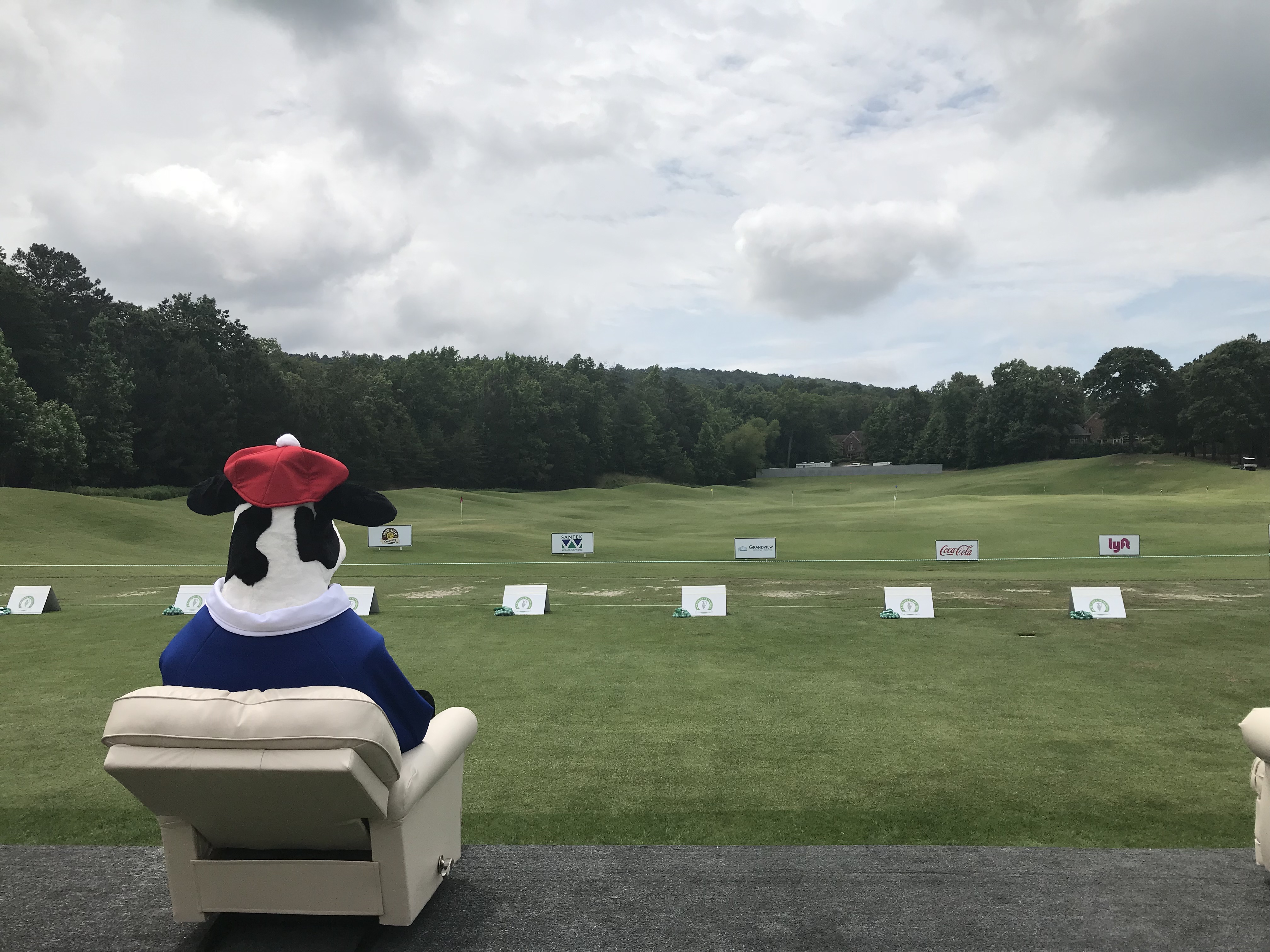 mascot seated and looking at golf range