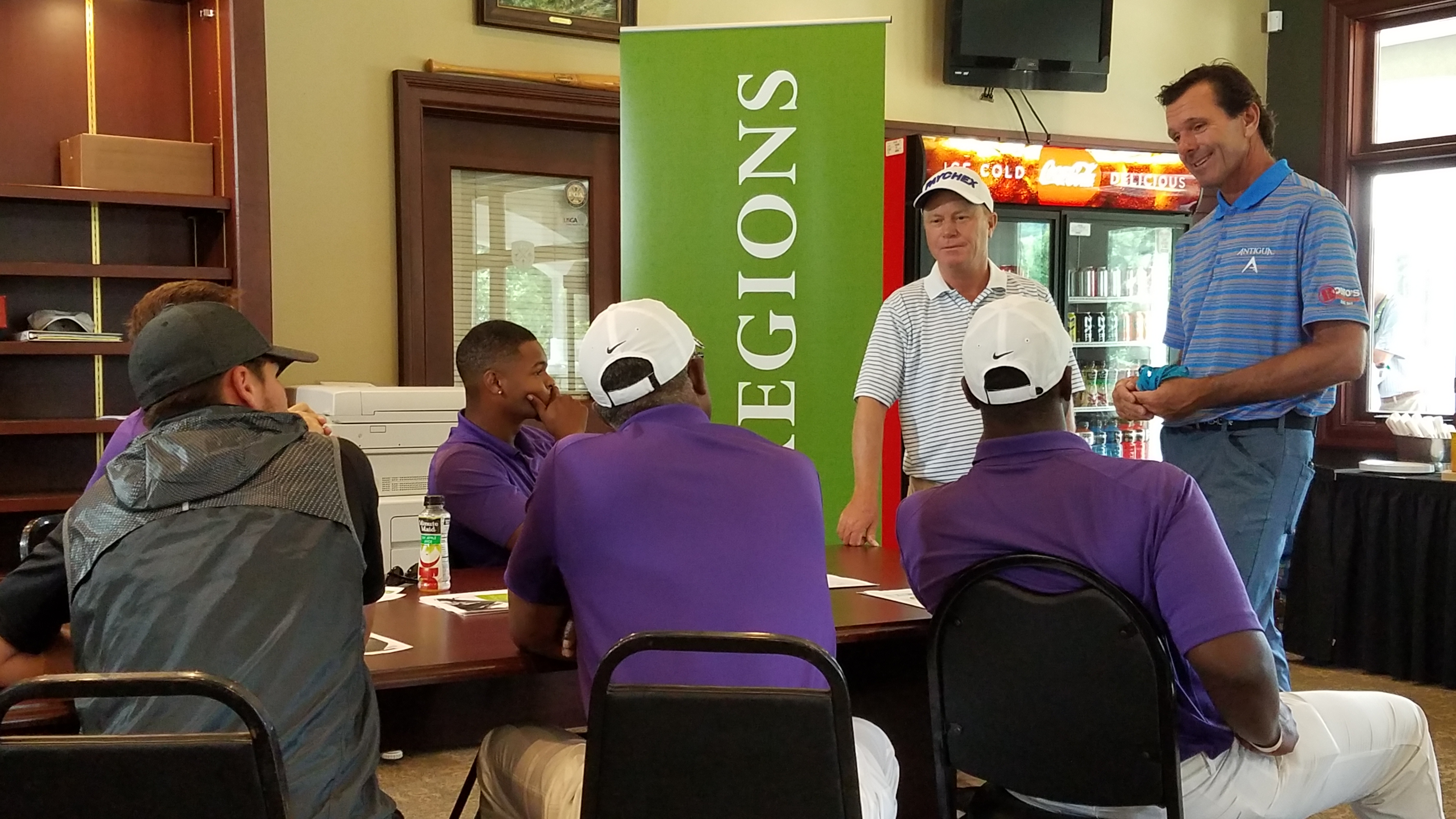 Miles College Golf Team seated at table listening to Jeff Sluman and Len Mattiace