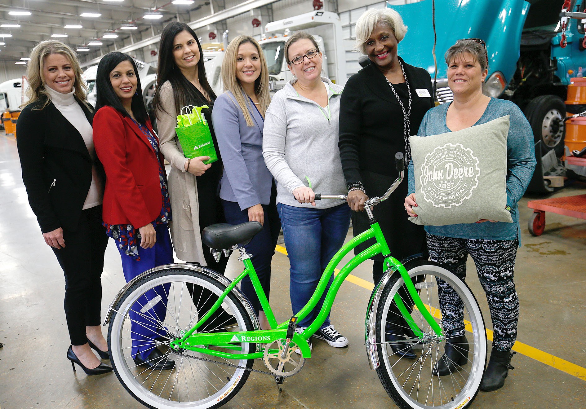 women standing together behind green bike