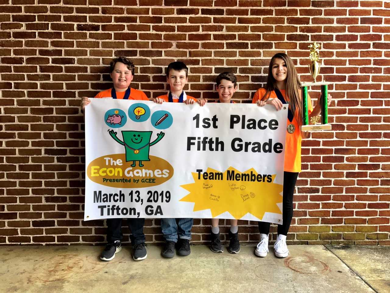 kids holding banner and trophy